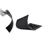Flexible black rubber mat being held and bent in a hand, showcasing its texture and design.